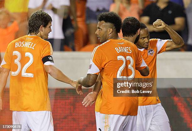 Ricardo Clark of the Houston Dynamo celebrates with teammates Giles Barnes and Adam Moffat and Bobby Boswell after his second-half goal against the...