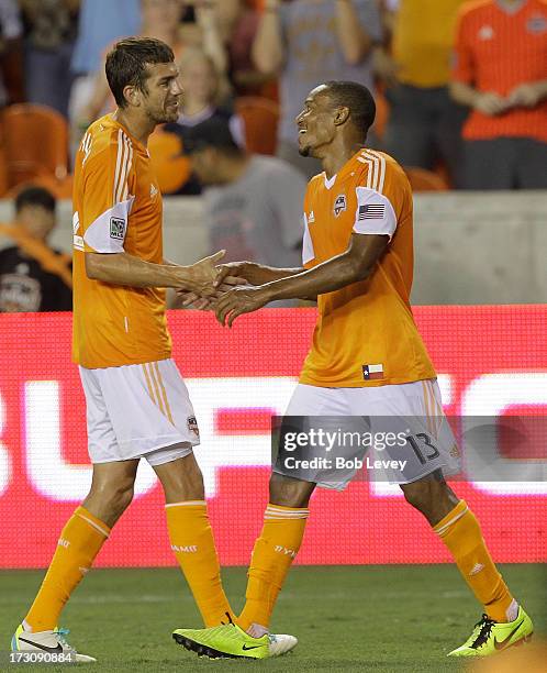 Eric Brunner of the Houston Dynamo congratulates Ricardo Clark of the Houston Dynamo after his header past goalkeeper Zac MacMath of the Philadelphia...