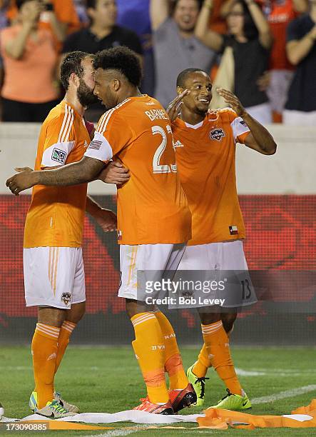 Ricardo Clark of the Houston Dynamo celebrates with teammates Giles Barnes and Adam Moffat after his second-half goal against the Philadelphia Union...