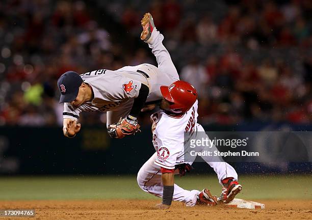 Shortstop Jose Iglesias of the Boston Red Sox flips over Erick Aybar of the Los Angeles Angels of Anaheim after tagging out Aybar at the end of a...