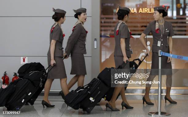 Asiana Airlines crew prepare to board their flight at the Incheon International Airport on July 7, 2013 in Incheon, South Korea. Two people are dead...