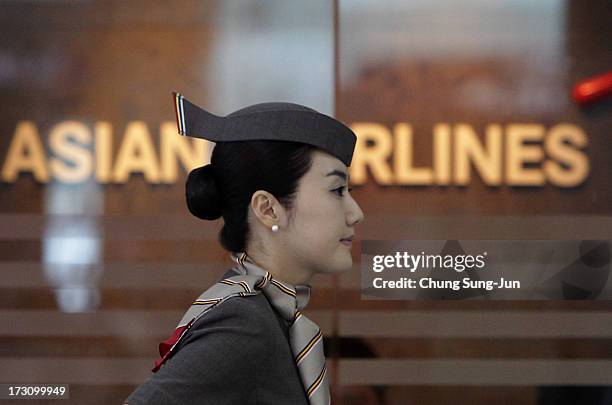 An Asiana Airlines crew prepare to board their flight at the Incheon International Airport on July 7, 2013 in Incheon, South Korea. Two people are...