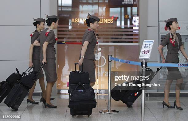 Asiana Airlines crew prepare to board their flight at the Incheon International Airport on July 7, 2013 in Incheon, South Korea. Two people are dead...