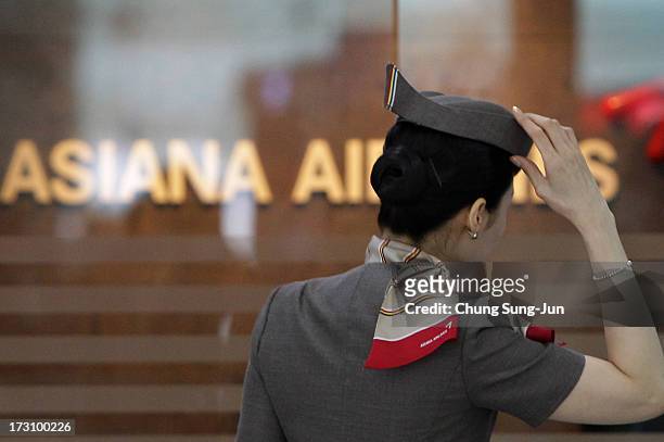 An Asiana Airlines crew prepare to board their flight at the Incheon International Airport on July 7, 2013 in Incheon, South Korea. Two people are...
