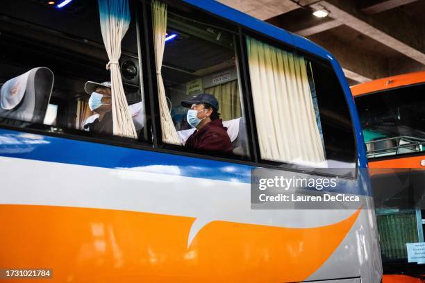 Thai migrant farm workers board a bus after arriving to Bangkok Suvarnabhumi Airport from Tel Aviv after a government evacuation on October 12, 2023...