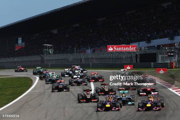 Sebastian Vettel of Germany and Infiniti Red Bull Racing and Mark Webber of Australia and Infiniti Red Bull Racing lead the field into the first...