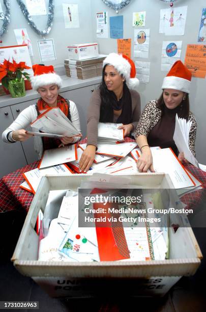 Letters to Santa fill Boston's Post Office. Photo shows Experian QAS employees Angela DiSanto, Sarah Root and Erin Haselkorn sorting through letters...