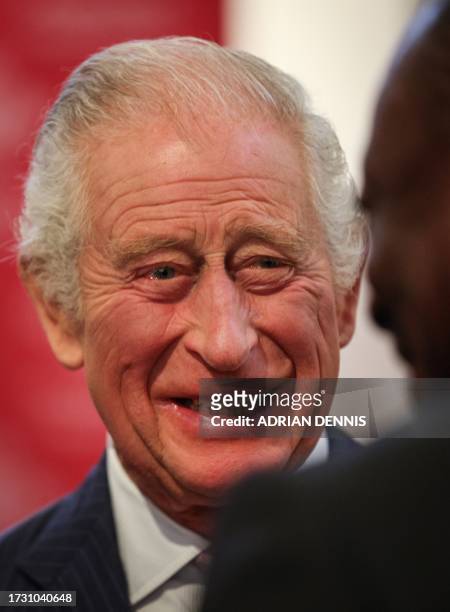 Britain's King Charles III reacts as he welcomes guests during a reception organised by The Prince's Trust International for African business...