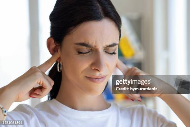 woman have tinnitus,noise whistling in her ears - handen over de oren stockfoto's en -beelden