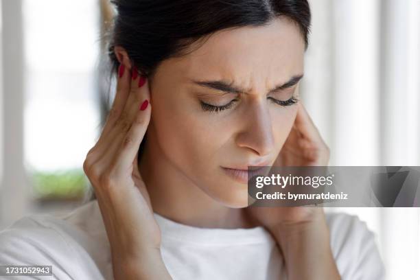 la mujer tiene tinnitus, ruido silbando en sus oídos - oído medio fotografías e imágenes de stock