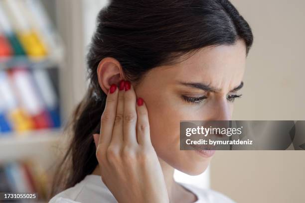 la mujer tiene tinnitus, ruido silbando en sus oídos - otitis fotografías e imágenes de stock