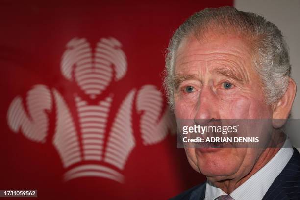 Britain's King Charles III stands by the logo of "The Prince's Trust" as he welcomes guests during a reception organised by The Prince's Trust...