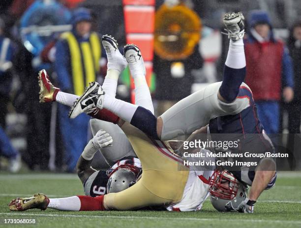 Foxboro - MA- - New England Patriots defensive end Justin Francis and defensive end Rob Ninkovich go head over heals as they sack San Francisco 49ers...