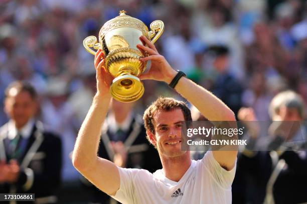 Britain's Andy Murray raises the winner's trophy after beating Serbia's Novak Djokovic in the men's singles final on day thirteen of the 2013...