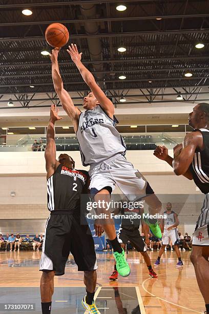 Michael Carter-Williams of the Philadelphia 76ers drives against Casper Ware of the Houston Rockets during the game between the Houston Rockets and...