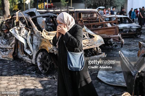 Woman is seen amid wreckage of vehicles after Al-Ahli Baptist Hospital was hit in Gaza City, Gaza on October 18, 2023. According to the Palestinian...
