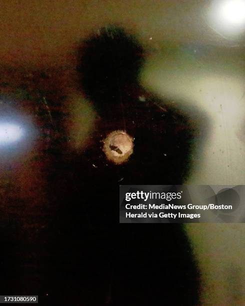 The victim is reflected in her TV that at the scene of a drive-by shooting at 214 Dudley Street in Roxbury on Sunday, December 17, 2017. Staff Photo...