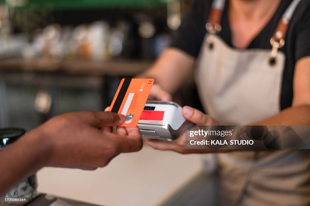 Woman using card to pay with contactless in a bar