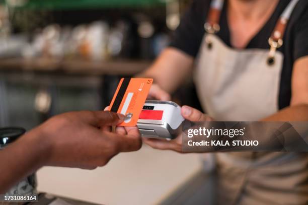 woman using card to pay with contactless in a bar - paying stock pictures, royalty-free photos & images