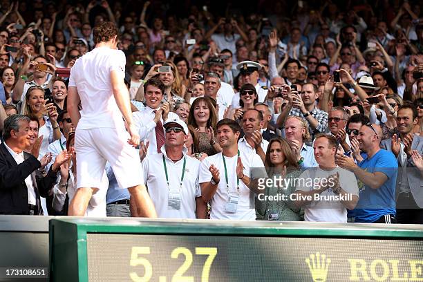 Andy Murray of Great Britain climbs into his player's box to celebrate with friends, family and members of his coaching team following his victory in...