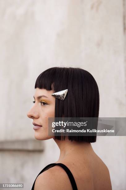 Maria Bottle wears Prada hair clips, a black Prada bra, a black low waist micro skirt, and a black bag outside Prada during the Milan Fashion Week -...