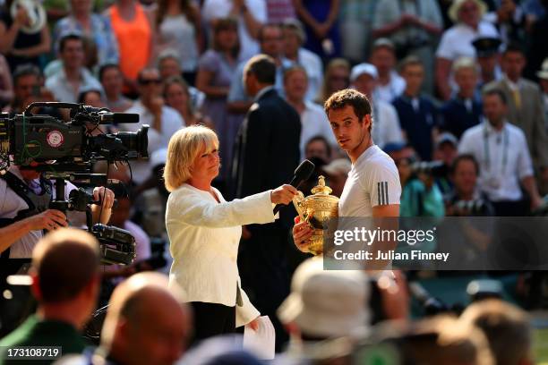 Andy Murray of Great Britain speaks with Sue Barker as he holds the Gentlemen's Singles Trophy following his victory in the Gentlemen's Singles Final...