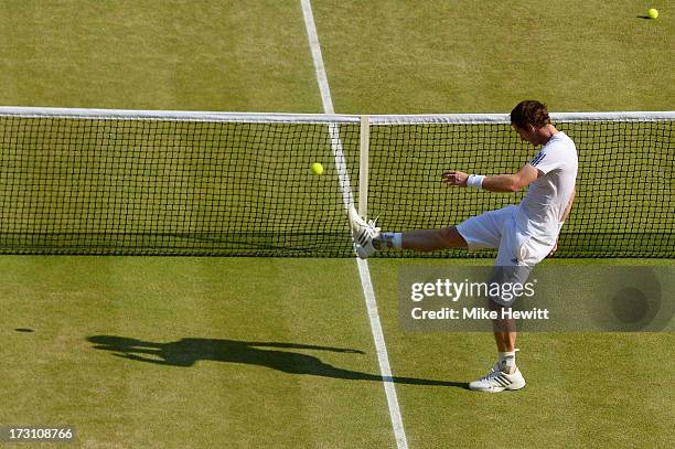 Andy Murray of Great Britain kicks a tennis ball as he celebrates victory in the Gentlemen's Singles Final match against Novak Djokovic of Serbia on...