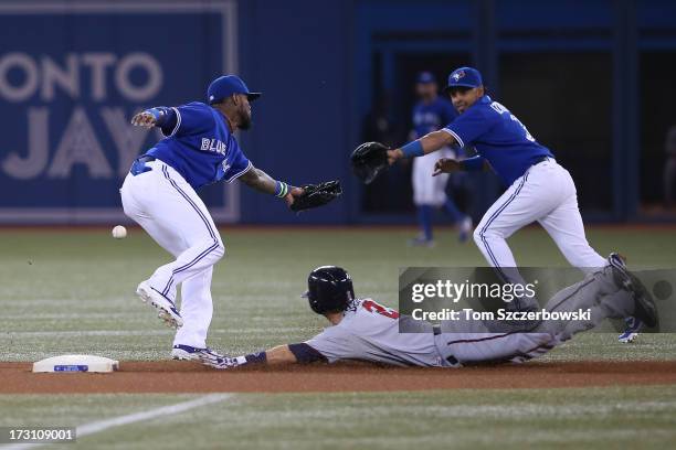 Brian Dozier of the Minnesota Twins steals second base in the first inning and will advance to third bas eon the throwing error by J.P. Arencibia of...