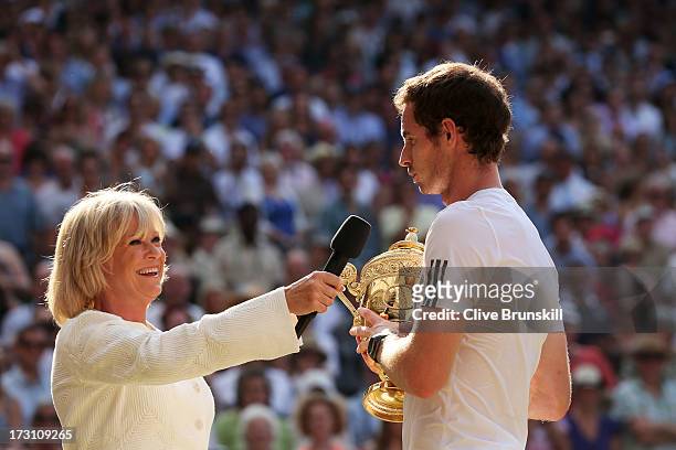 Andy Murray of Great Britain speaks with Sue Barker as he holds the Gentlemen's Singles Trophy following his victory in the Gentlemen's Singles Final...