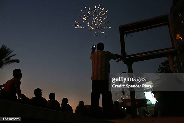 Fireworks are viewed as tens of thousands of people attend a rally in Tahrir Square against ousted Egyptian President Mohamed Morsi on July 7, 2013...