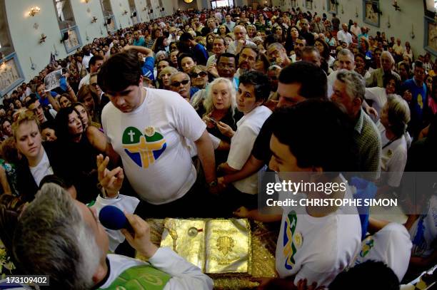 Priests addresses to the faithful asking them to keep calm as they gather around the relics after a mass officiated by Cardinal Stanislaw Rylko to...