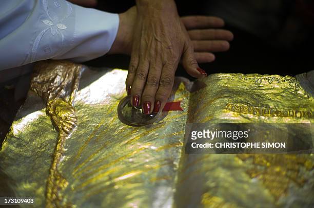 Woman touches a relic after a mass officiated by Cardinal Stanislaw Rylko to celebrate the arrival in Brazil of the relics of blessed John Paul II at...