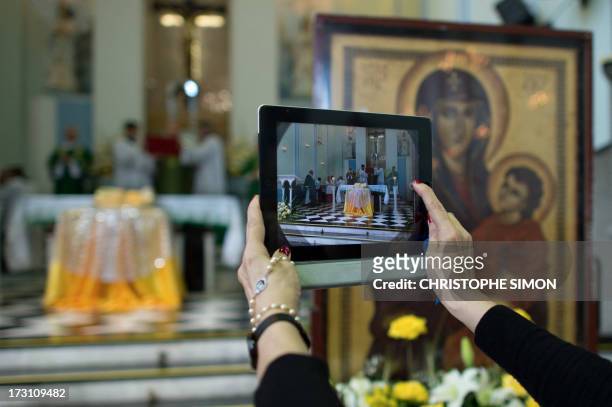 Woman takes a snapshot with her iPad of the altar with the relics of blessed John Paul II at the Medalha Milagrosa sanctuary in Rio de Janeiro,...