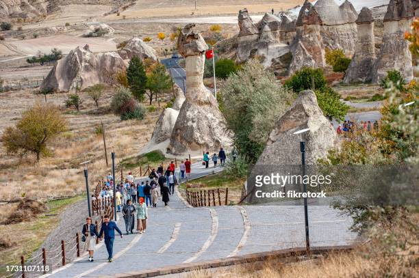 tourists walking in paşabağı - göreme stock pictures, royalty-free photos & images