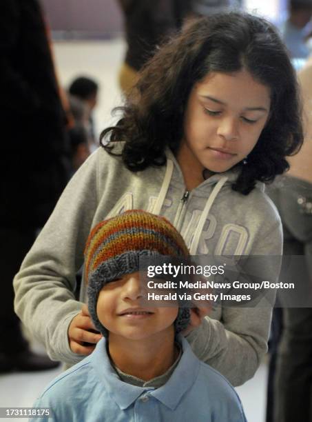 Boston, MA, - 121912- Interview subject 10 yr old, 5th grader Freddy Baez adjusts a handmade hat on the head of 5 year old Jose Hernandez at The...