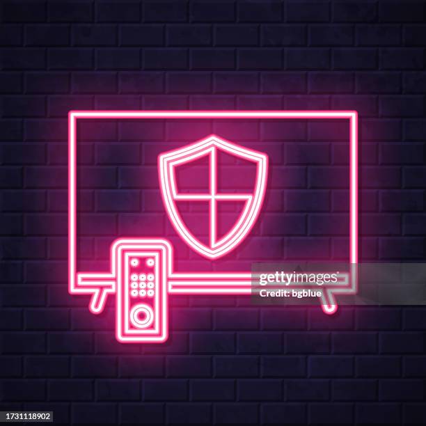 tv with shield. glowing neon icon on brick wall background - flat screen on wall stock illustrations