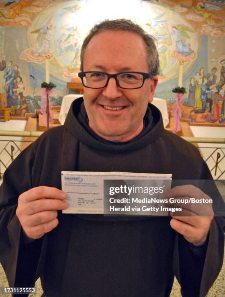 Thomas E. Conway O.F.M. Executive Director of St. Anthony's Shrine holds a check from the Massachusetts Lottery. Staff photo Chris Christo Thomas E....