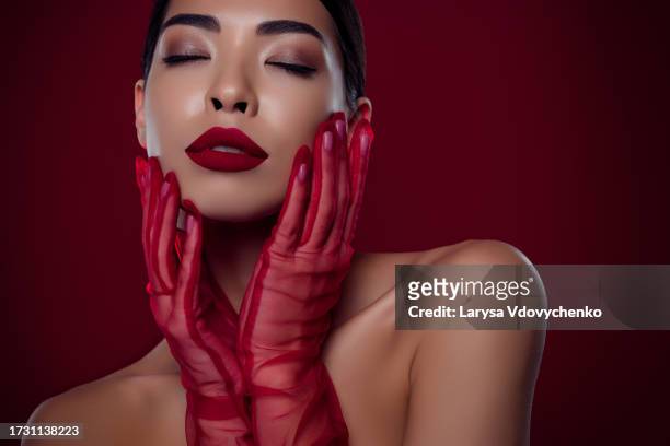 photo of asian young girl femme fatale touch cheeks closed eyes tease shoulders off isolated dark red color background - femme glamour stock pictures, royalty-free photos & images
