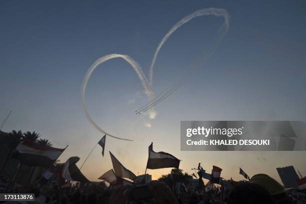 Egyptian jet fighters trail smoke as they fly over Tahrir Square, in Cairo, on July 7 as tens of thousands of people staged a show of force in Tahrir...