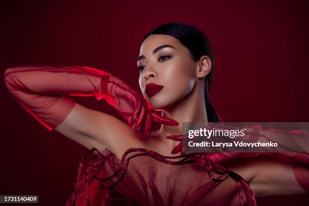 photo of asian young lady femme fatale touch chin lace gloves passion shoulders off isolated dark red color background - femme glamour stock pictures, royalty-free photos & images