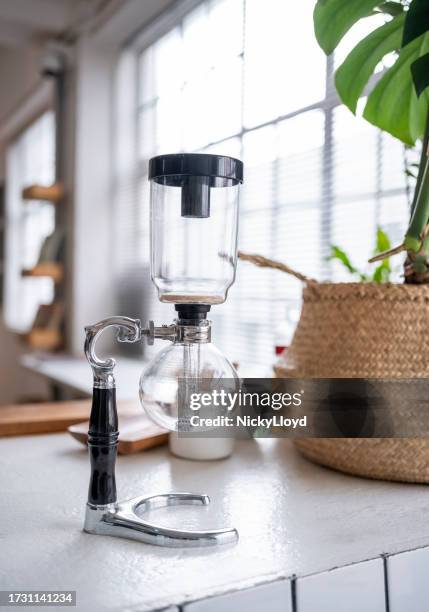 siphon coffee maker on cafe counter sleek siphon coffee maker elegantly displayed on a cafe counter - siphon stock pictures, royalty-free photos & images