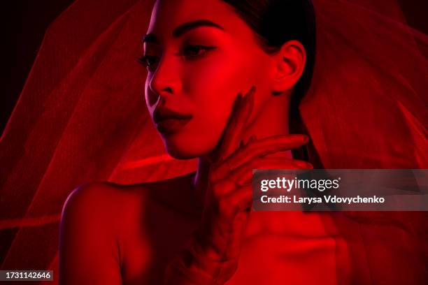 photo of lovely asian girl femme fatale veil wedding bride shoulders off isolated dark red neon light color background - femme glamour stock pictures, royalty-free photos & images