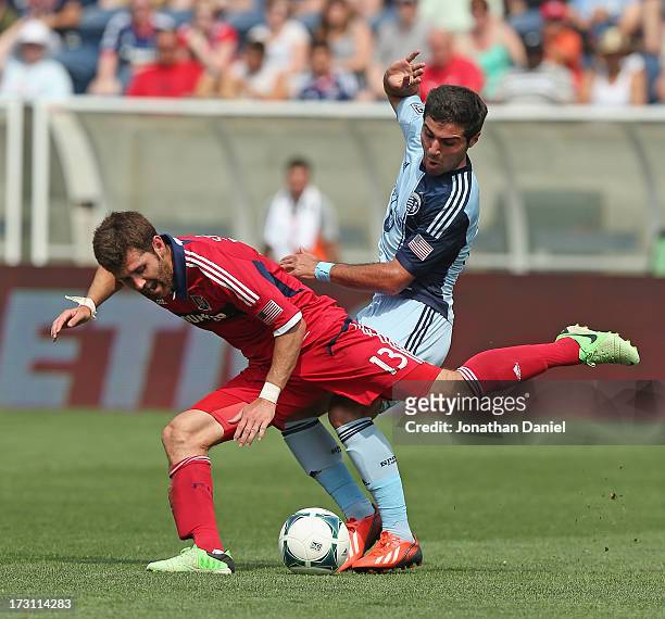 Soony Saad of Sporting Kansas City knocks down Gonzalo Segares of the Chicago Fire during an MLS match at Toyota Park on July 7, 2013 in Bridgeview,...