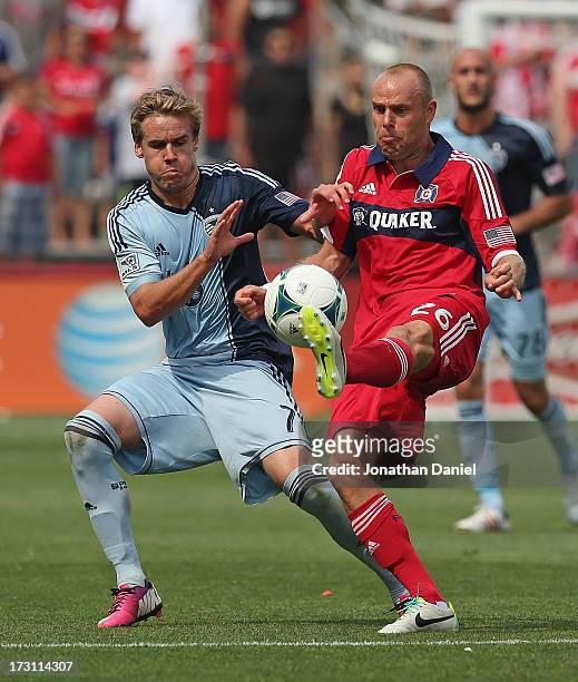 Joel Lindpere of the Chicago Fire kicks the ball away from Chance Myers of Sporting Kansas City during an MLS match at Toyota Park on July 7, 2013 in...