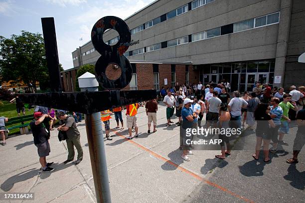 Families wait outside the emergency camp set up at Lac-Mégantic high school on July 7, 2013 in Lac-Megantic, Quebec, Canada, one day after a train...