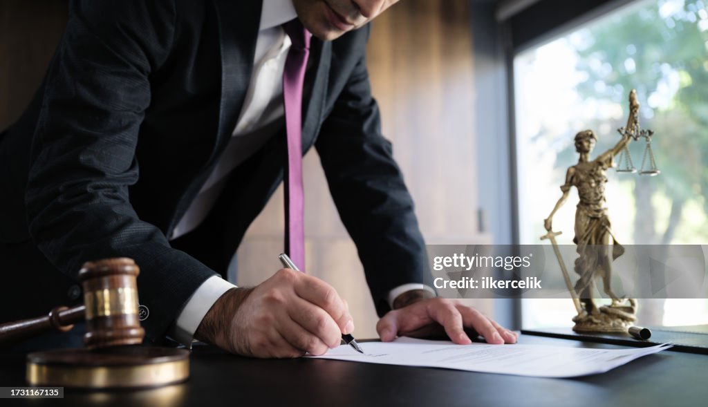 Judge or Legal advisor lawyer examining and signing legal documents.