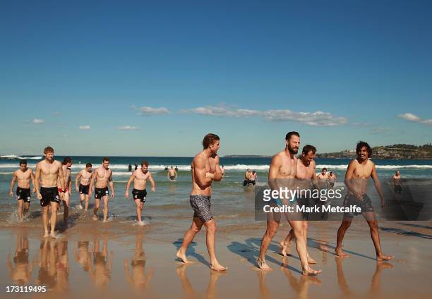 Swans players walk from the ocean during a Sydney Swans AFL recovery session at North Bondi Beach on July 8, 2013 in Sydney, Australia.