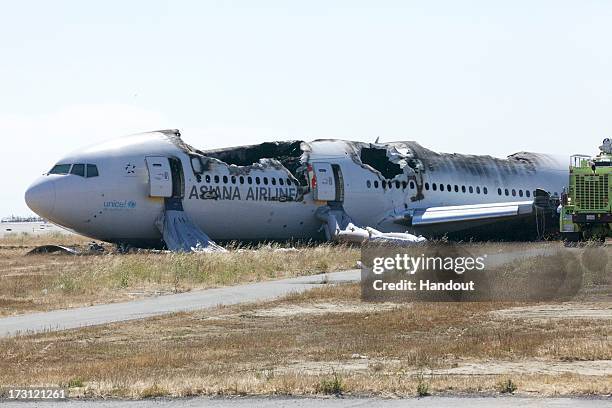 In this handout photo provided by the National Transportation Safety Board, the wreckage of Asiana Airlines flight 214 lies near the runway following...