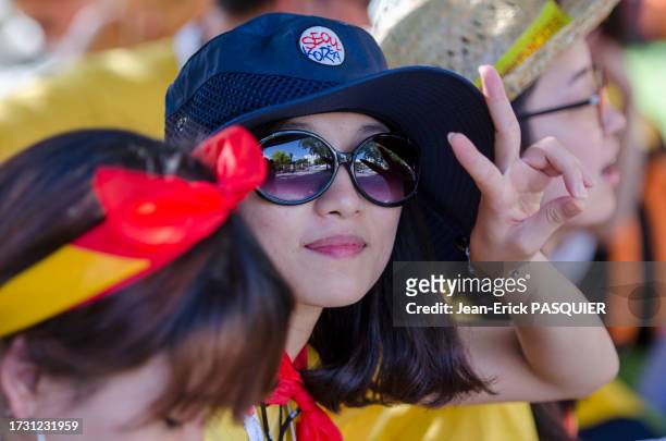Jeune femme avec des lunettes de soleil et un chapeau lors des journées mondiales de la jeunesse le 17 août 2011 à Madrid.