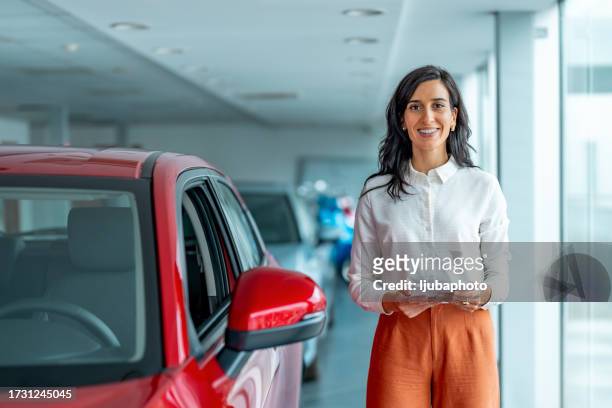 woman posing near automobile in car dealership. - audi showroom stock pictures, royalty-free photos & images